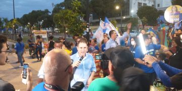 Edivaldo caminha na rua Grande com um pequeno grupo de apoiadores